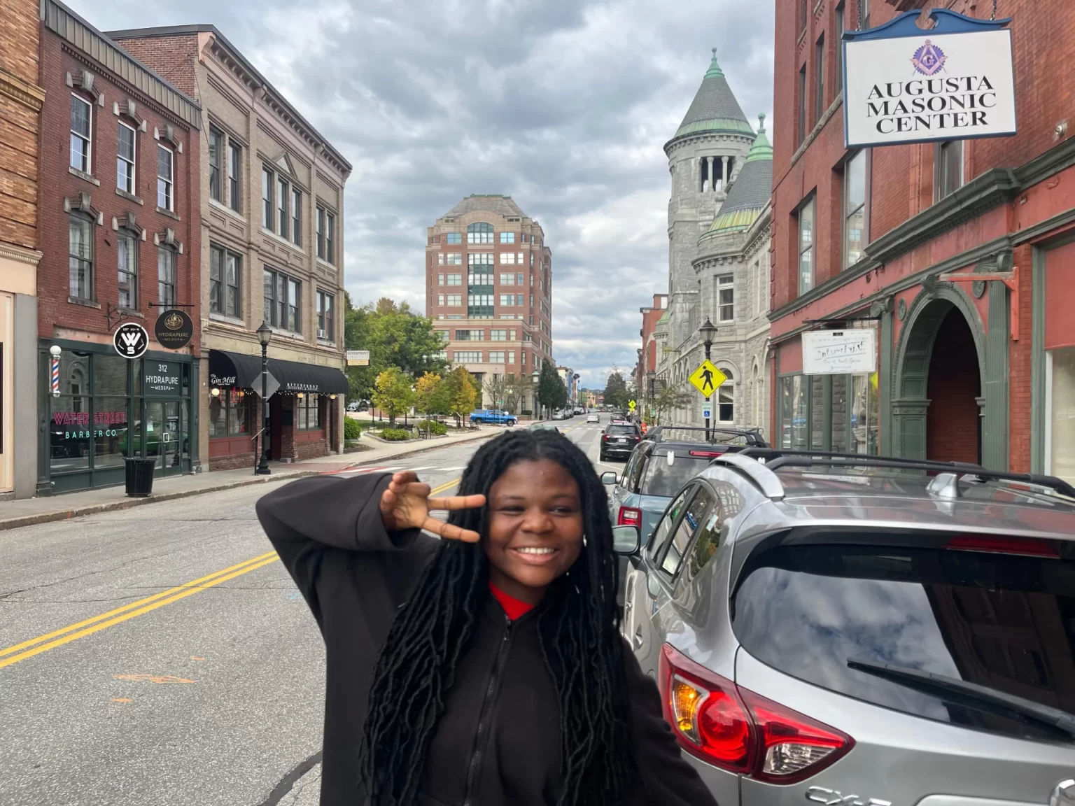 a student poses on a city street