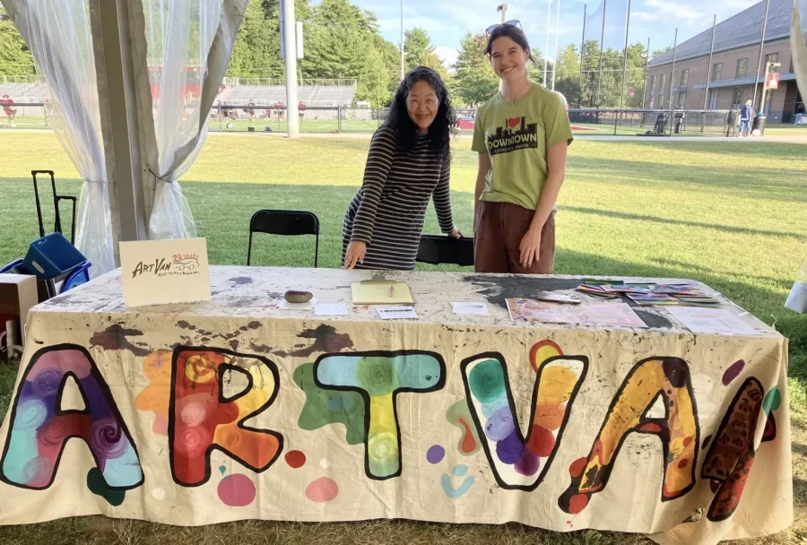 a student poses in front of table that says "Art Van"