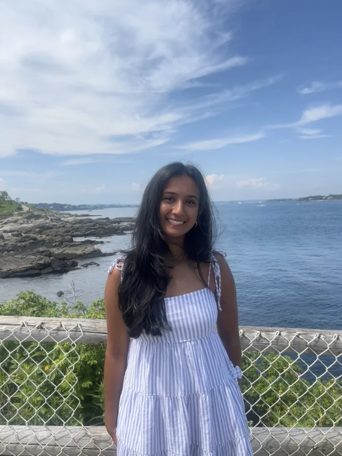 a student standing in front of a scenic ocean lookout