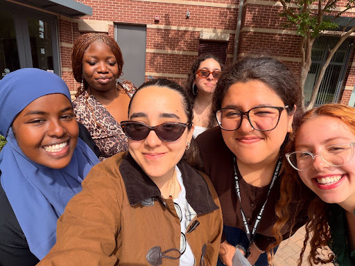 A group of conference attendees smiling in front of a campus building