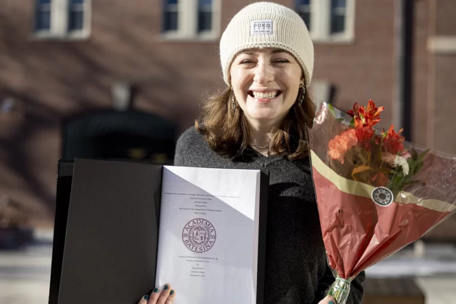 Ilana Rosker ’23 of Lexington,Mass.,(hat), a major in Hispanic Studies, and Emma Pike ’23 of York, Maine, a major in Hispanic studies, bind their theses in the company of friends on the Library Terrace on Dec. 13, 2022.

Rosker wrote on “La imagination, la rapture y la magia: Hacienda espacio para la conciencia alternativa a traves de la poesia Latin X.”

Pike wrote on “Llimpia bus propoios Platos!: explorando masculinidad hegemonica en Jane the Virgin.”