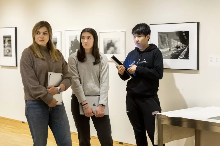 Historical Methods class, taught by Associate Professor of History Caroline Shaw, meets in the Lower Gallery of the Museum of Art in the Olin Arts Center. Working with Peter Philbin í22, assistant museum curator, the students broke into several groups to consider four works of art, and how they would use that artwork along with other pieces in the museum collection, to create an exhibition.

HIST 399 - Historical Methods
This seminar refines students' proficiency as historians and prepares them to write their senior thesis. The course is designed around two interrelated goals. First, students analyze how different approaches to history and sources matter to understandings of the past. Second, students design and test their own arguments, drawing upon critical readings of primary sources and close engagement with historiography. The course culminates in the completion of individual thesis proposals. Prerequisite(s): one HIST 301 seminar.

Students at table, from head of the table, left:

Hanna Matthews í24, brown sweater, long blonde hair
Matt Connelly í24, white shirt
Chris Ly í24, black hoodie
Emily Everett í24, light gray sweater
Bridget Lee í24, gray sweater, brown pants
Ben Fasciano í23, gray sweater
James Guinee í24,blue/green sweater
Ned Farrington í24, blue flannel
Sebastien Kleitman í24, black hat
Luke Linnehan í24, black baseball hoodie and hat
Campbell McKendry í24, black sweater, brown hat