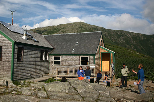 Helon Hoffer 08 (right) gives a green-tech tour to hikers outside the Greenleaf hut.