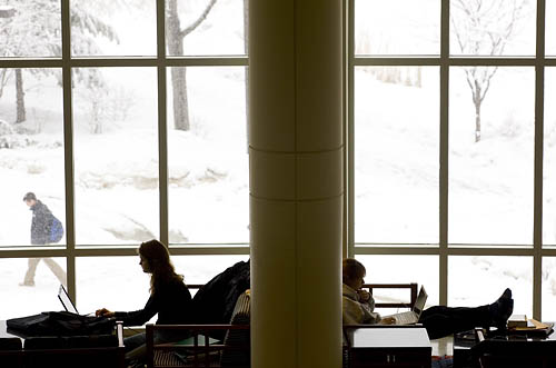 Students study in Pettengill Halls Perry Atrium as an early spring snow blankets the campus.