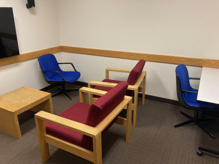 Study room with three lounge chairs, a desk and office chair, whiteboard, tv, DVD/bluray player