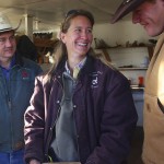 Krista Kaplan (center) and her husband, Bill Burleigh (left) go over morning assignments with Will Kupec at the Laramie River Dude Ranch. Photograph by Shauna Stephenson.