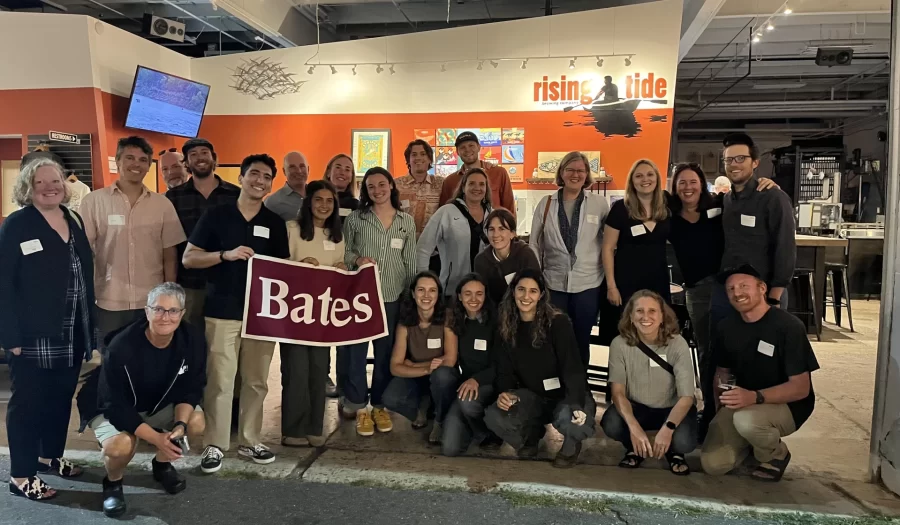 Alumni from various classes meet for a Bates happy hour at a brewery in Portland, Maine on Sept. 18. The gatherings are an ongoing thing and have already been planned into autumn 2026. In this group shot taken at Rising Tide Brewing Co., Brad appears in the back row, third from left, and Tracy is in the middle row, second from right. (Photo: Chelsea Turner ’94) <br>