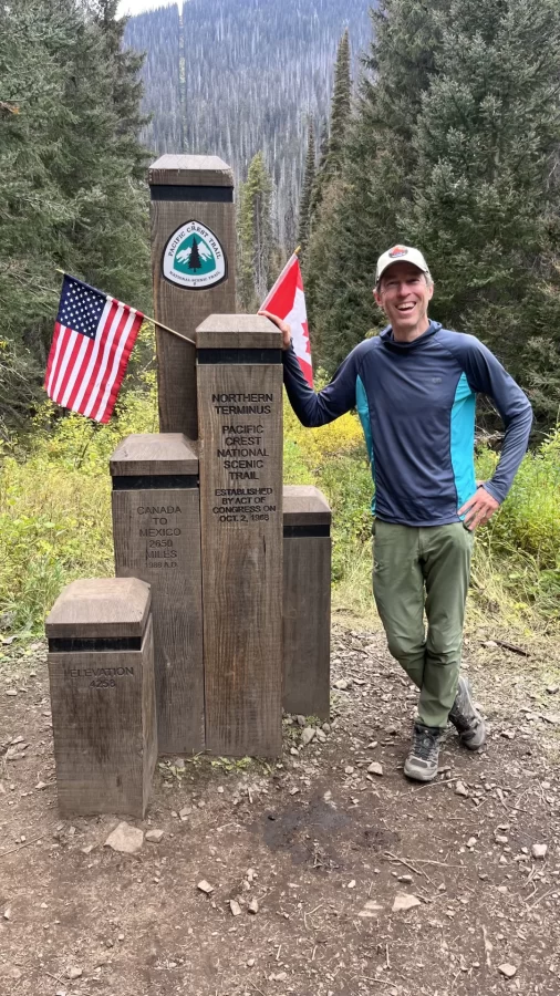 Sandy Somers poses at the northern terminus of the Pacific Crest Trail
