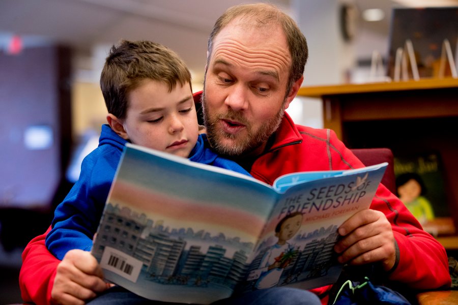 Matt Schlobohm '00 reads a book with his son Avery, 6, in Ladd Library during the 2018 Martin Luther King Jr. Day workshop "Friends Across Difference." (Phyllis Graber Jensen/Bates College)