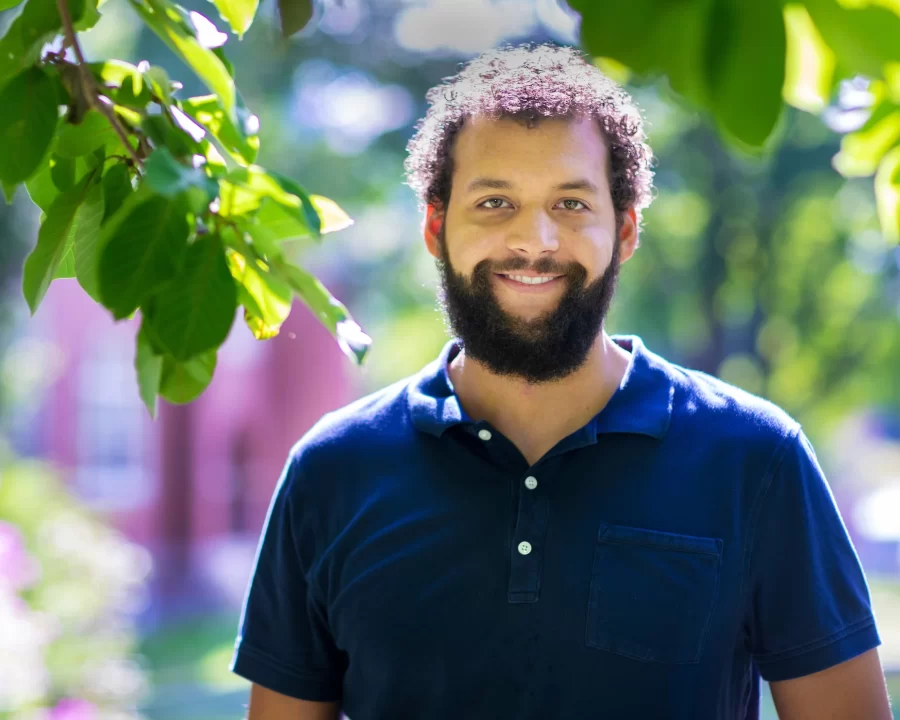 Assistant Professor of Environmental Studies Tyler Harper photographed on the historic Quad, on the steps of Hedge Hall and moving books into his Hedge Hall office on Aug. 14, 2020.