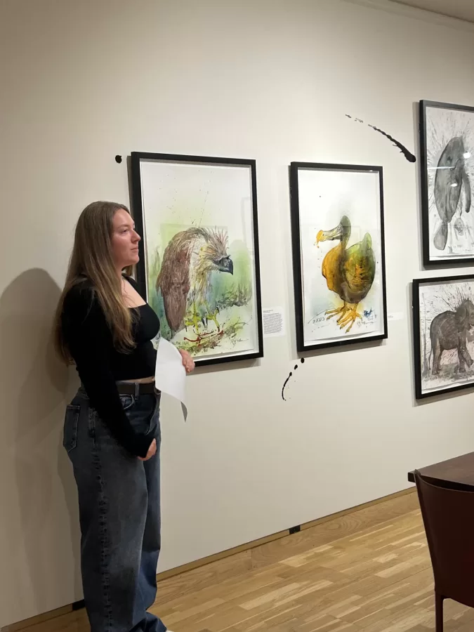 Intern Brigid Gaffny ‘28 talks animal conservation in front of Ralph Steadman illustrations