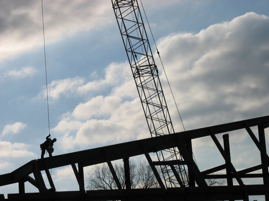 Look, skywalker: On the skeleton of the new dining Commons, a worker unhooks a newly set piece of steel from the crane. (Doug Hubley/Bates College)