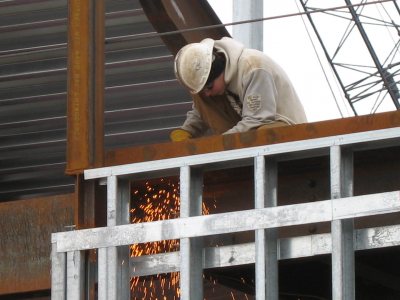 A welder makes sparks on the new Commons. (Doug Hubley/Bates College)