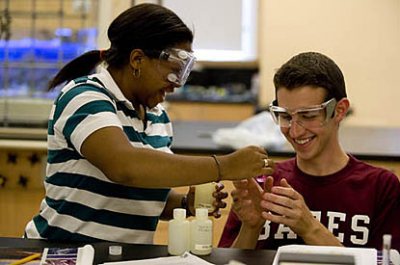 The Hughes Summer Scholars Program from June 22 -  Aug. 1,has 11 incoming first-year students to the campus for a 6-week "summer term" in which they take two courses to start them early on their Bates career. The goals of the program are to encourage a diverse group of students to study science and math and to persist in those disciplines, to develop intellectual and social connections with each other and with other science and math students, and to make connections with faculty members.

The Summer Scholars Program is designed to bring to campus a group of incoming first-years â including students from groups traditionally underrepresented in the sciences â who have a keen interest in math and science. Admission to the program was by application and a competitive selection process. One of those students is working with the program this year to help 
continue building a community of science scholars.

This program of accelerated study in which the students take a first-year seminar in the chemistry taught by (SHOWN IN PHOTOS in black leotard) Jennifer Koviach-CÃ´tÃ© (who will become their academic advisor), and an ethnomathematics course 
taught by Grace Coulombe. The faculty will be assisted by teaching assistants Hilary Ginsburg '09 (with purple solution and dry ice) (chemistry) and Hong Nguyen '11 (math), an alumnus of the 2007 Hughes Summer Scholars Program.

Group of three: Shaunyce Johnson '12 of Randolph, ME (plaid); Reann Gibson '12 of Boston; Cameron Hamilton '12 of  Lee, ME

Pair: Sarah Dominque '12 of Cambridge, Mass., and Antonio Lewis '12 of Springfield;

Pair: Lesley Mo '12 of Waterville, ME, and Shashi Shankar '12 of Groveland, Mass.

Pair in corner: Olivia Moody '12 of Boston and Reid Christian '12 of Pownal;

First two: Zelford Leonard '12 of Cliffwood, NJ, and Nazsa Baker '12 (red shirt) of East Orange, NJ
Students are looking at the relationship between absorbance and concentration of the purple solution -- potassium permanganate -- using spec 20 instruments