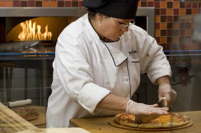 Bates Dining pizza chefs Chris Davis and Tina Vallerand make pizzas at the brick oven in the new Bates Dining Commons.