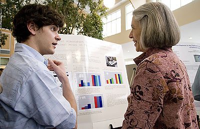 Owen Harris '08 of Bedford, Mass., discusses his research in neuroscience on therapies for Parkinson's disease with President Elaine Tuttle Hansen.
Psychology major Jennifer Imrich '08 of Cambridge, Mass., receives a hug from Sean Wilkinson '08, also of Cambridge, after explaining her research on the impact of post-identification feedback to eyewitnesses and jurors. Imrich's mother, Cynthia Smith, smiles in the foreground.