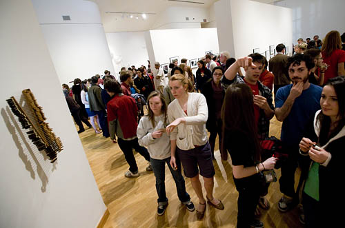 Fourteen studio art majors from Bates College show work from their yearlong thesis projects in the annual Senior Exhibition. The show opens with a reception at 6 p.m. Friday, April 10, in the Bates College Museum of Art, 75 Russell St.

The exhibition runs through May 30. Open to the public at no cost, the museum's regular hours are from 10 a.m. to 5 p.m. Tuesday through Saturday. For more information, please call 207-786-6158 or visit www.bates.edu/museum.xml.

The Senior Exhibition artists are:

H. Lincoln Benedict of Shaftsbury, Vt.;

Sarah Codraro of Hancock, Maine;

Hannah Davis of Bainbridge Island, Wa.;

Ryan Dean of Cranston, R.I.;

William Gardner of Waitsfield, Vt.;

Rachel Kaplan of Westport, Conn.;

Jessica Kase of Chappaqua, N.Y.;

Elise Kornack of Dover, Mass.;

Madeline McLean of Evergreen, Colo.;

Elizabeth Mitchell of Auburn, Maine;

Hwei Ling Ng of Selangor, Malaysia;

Tyler Schoen of Wilton, Maine;

Jason Tsichlis of Winchester, Mass.;

and Margot Webel of Locust Valley, N.Y.

As their senior thesis requirement, studio art majors at Bates create a substantial and cohesive body of work through studio practice and critical inquiry. The yearlong process is overseen by faculty and culminates in this exhibition.

The requirement allows students to develop independence and consistency. They achieve greater depth with their artwork and learn to work both critically and productively.Student artist Elise Kornack ;09 of Dover, Mass., (in orange print dress) with her parents Margaret and Fulton, and her brother Evan '06 (in dark turtleneck), looking at Elise's work.