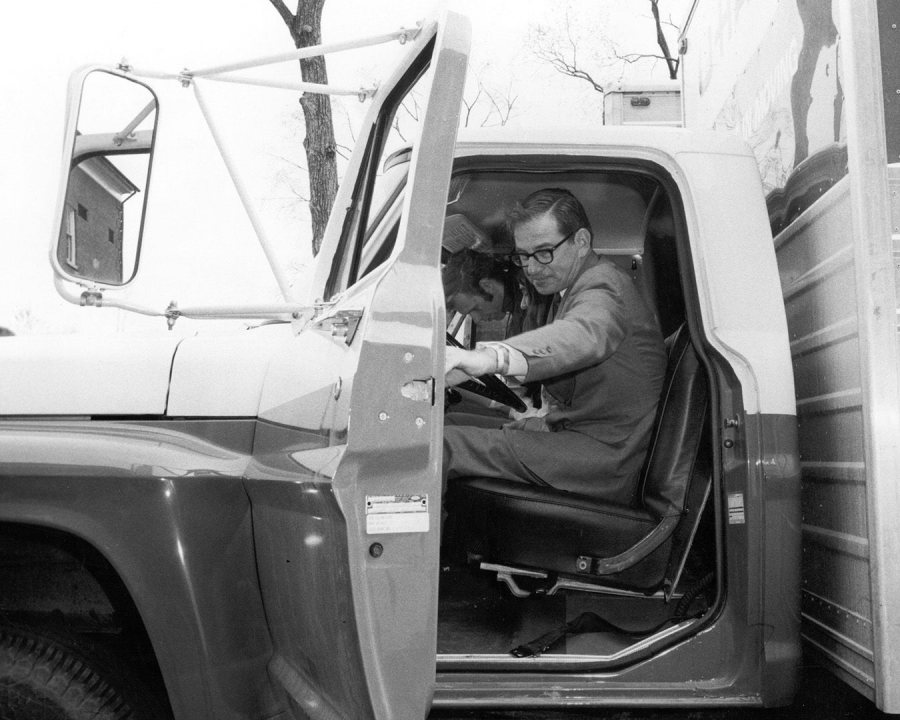 In May 1970, Bates President Thomas Hedley Reynolds climbs into the cab of a donated U-Haul truck to lead Bates students on a strike project: a downtown Lewiston trash cleanup. (Muskie Archives and Special Collections Library)