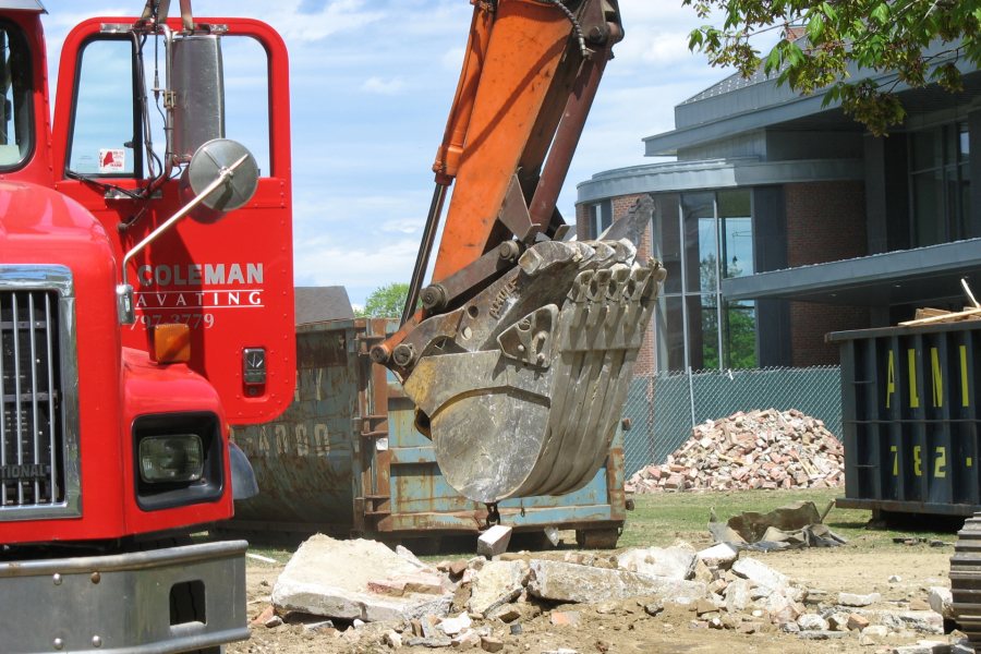 Scooping up rubble, Barney, from demolition in the basement of Hedge Hall. (Doug Hubley/Bates College)