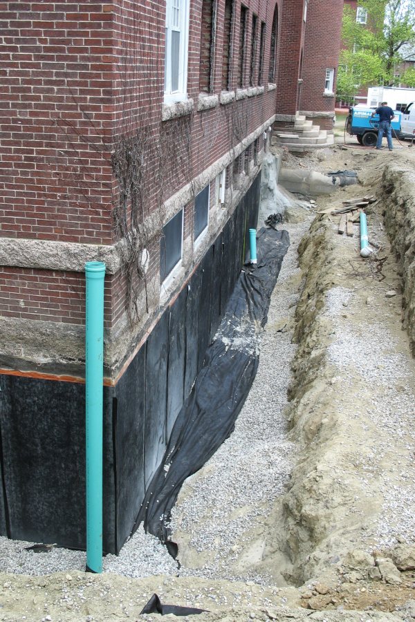 Applying waterproofing to the foundation of Hedge Hall. (Doug Hubley/Bates College)