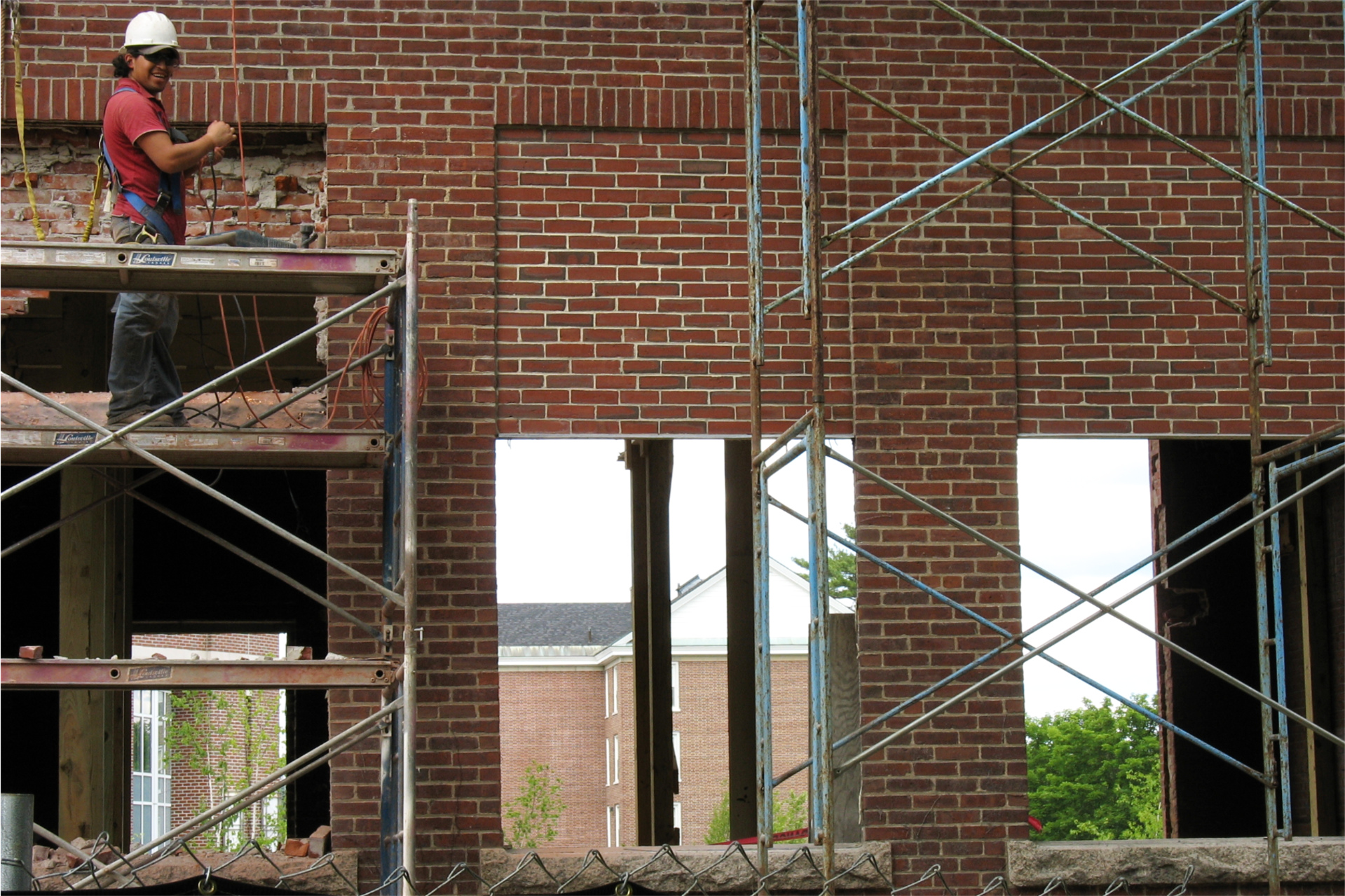 With a large hole opened in the north side to accommdate a stair tower and much of the interior gutted, Hedge Hall's south windows save one the trouble of circling around the building to see what's happening. (Doug Hubley/Bates College)