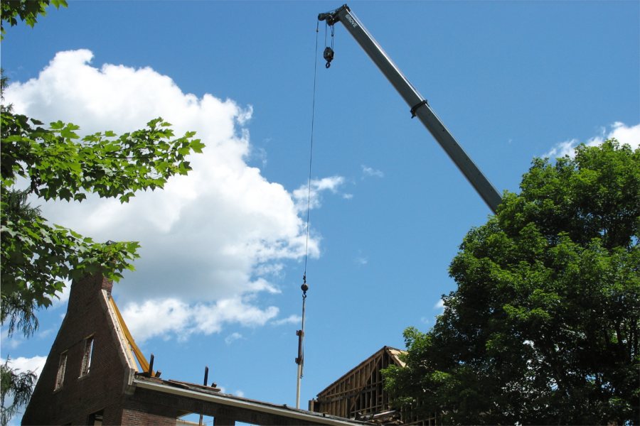 Razed roof: A crane plucks old steel support columns from a half-roofed Hedge Hall. (Doug Hubley/Bates College)