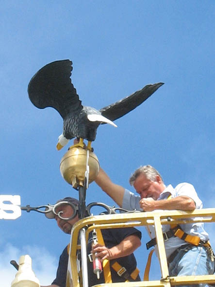 Chouinard and Winslow remount the weathervane atop the carriage house.