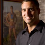 From 2007, this portrait of Peter Carlisle '91 was taken in his Portland, Maine, office. The poster behind Carlisle shows Michael Phelps wearing his Olympic medals in Athens. Photograph by Phyllis Graber Jensen / Bates College.