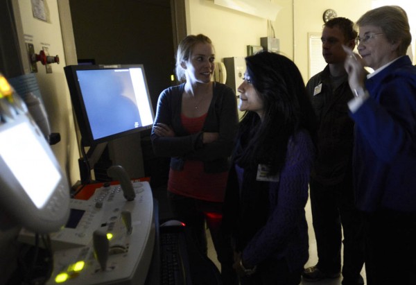 Director of radiology at St. Mary's Regional Medical Center, Donna Knightly demonstrates an X-ray machine for Samantha Forrest '13, Raisa Sharmin '13, and Keyan Riddell '16. Photograph by Michael Bradley/Bates College.