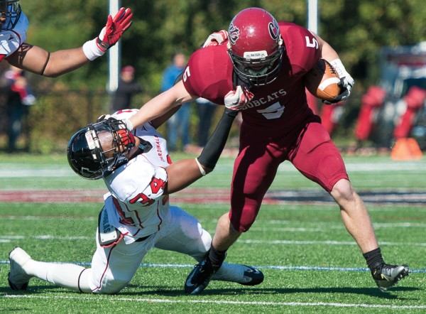 Slot receiver Mac Jackson ’15 of Hood River, Ore., stiff-arms a Wesleyan defender — emblematic of coach Mark Harriman’s statement that the Bobcats in 2012 were physically on par with any NESCAC team. Photograph by Mike Bradley