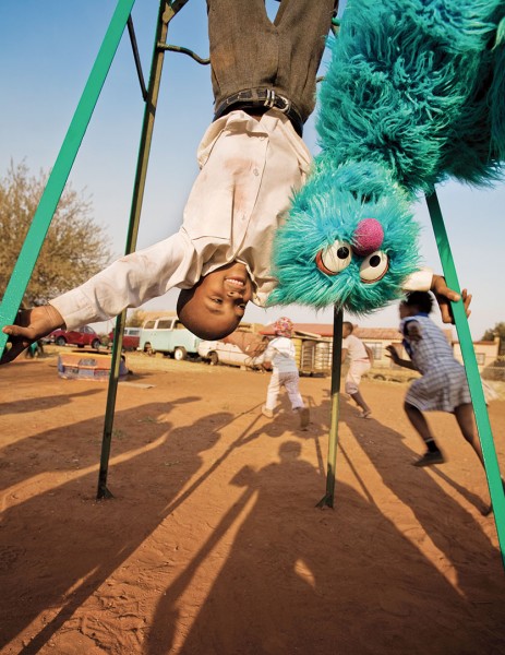 Child with Sesame Street character, Soweto, South Africa, for a Sesame Workshop report on international programs. Photograph by Ryan Heffernan '05