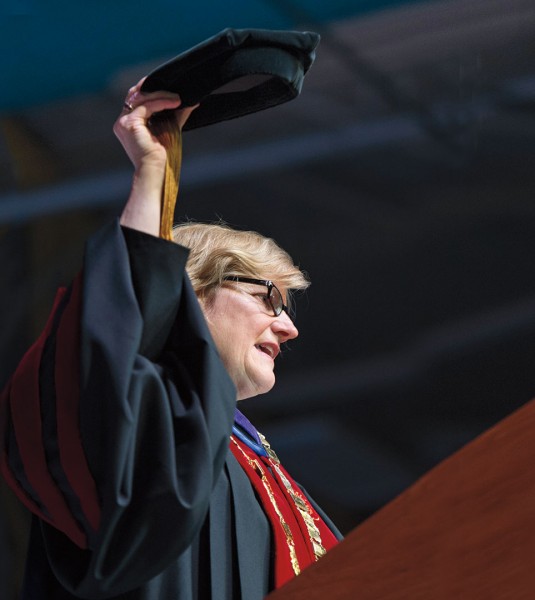 A poignant moment during the installation: Clayton Spencer hoists her academic cap, the same one that her father, Samuel Reid Spencer Jr., now 93, wore as president of Mary Baldwin College and Davidson College. Photograph by Mike Bradley