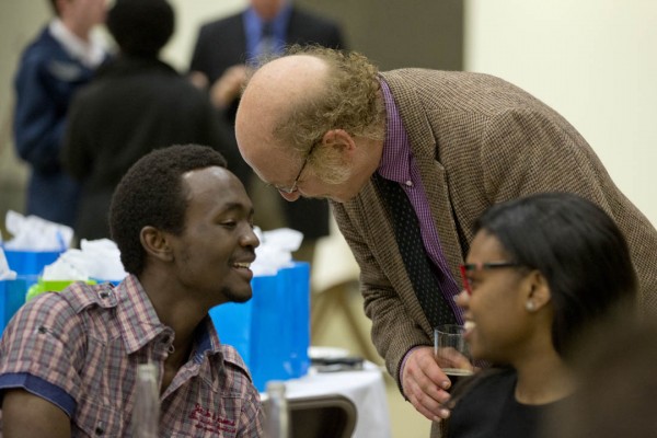 Associate Professor of English Sanford Freedman greets Desmond Mushi '13 at the Annual Senior-Faculty Dinner, held in the Gray Cage. (Phyllis Graber Jensen/Bates College)