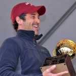 Dempsey laughs while holding the CBB Challenge Cup, inscribed with the first winner: Bates College. (Meg Kimmel/Bates College)
