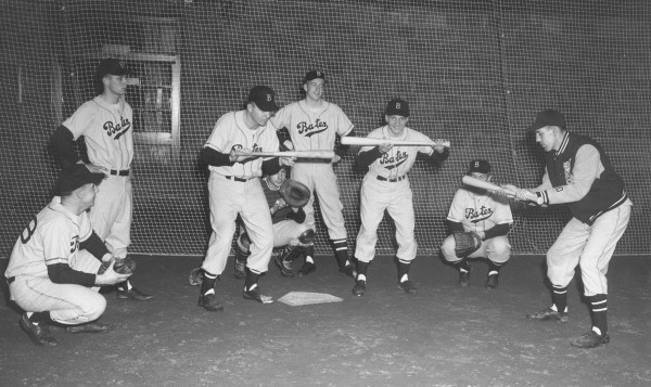 Head coach Chick Leahey '52 demonstrates bunting technique during a practice in Gray Athletic Building in the 1950s. (Muskie Archives and Special Colleciton Library)