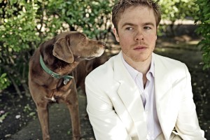 Singer-songwriter Josh Ritter is pictured outdoors with a dog.