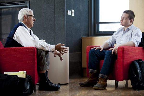 Bruce Stangle ‘70, left, and Harry Sudock '15 discuss some of the points that Stangle addresses in the "Market Efficiency vs. Behavioral Finance" forum that he led in 2005, during a one-on-one meeting in Fireplace Lounge in Commons on March 5, 2014. (Sarah Crosby/Bates College)