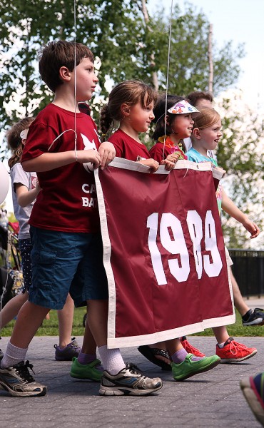 Children of Class of 1989 alumni carry the class banner during the Alumni Parade on June 7. (Jay Burns/Bates College)