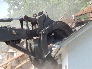 Got house? A power shovel demolishes a Bates-owned house at 67 Campus Ave. (Doug Hubley/Bates College)