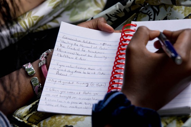 Grace Ingabire '18 of Kigali, Rwanda, takes notes during the 2014 Convocation address by Matt Auer, vice president for academic affairs and dean of the faculty. (Phyllis Graber Jensen/Bates College)