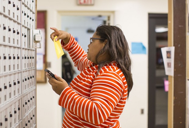 Jacqueline Cooper '17 of Chicago pulls a yellow slip from her Chase Hall mailbox alerting her that she has a package awaiting her in the Package Center. Her prize? A DVD of "The Great Gatsby" that her mom sent her. (Phyllis Graber Jensen/Bates College)