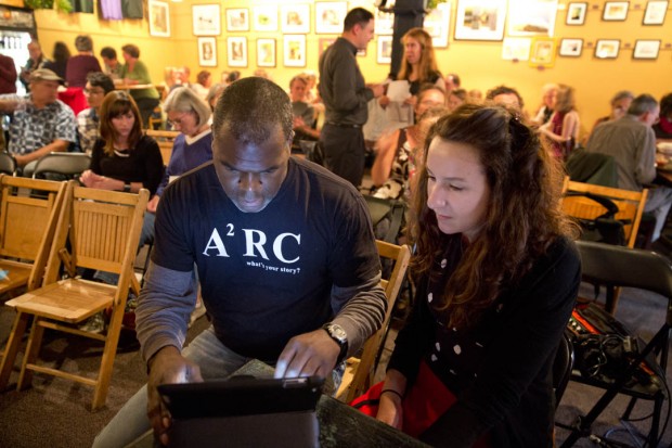 Psychology professor Michael Sargent confers with volunteer Molly Pailet '15 of Denver, Colo., prior to The Corner, a monthly storytelling event at Guthrie’s in Lewiston. Sargent is event founder and host. (Phyllis Graber Jensen/Bates College) 