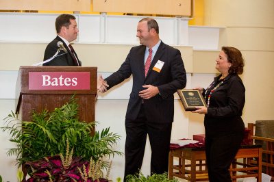 Stuart Abelson '97 accepts congratulations from Michael Lieber '92 after receiving the Bruce Stangle ’70 Award for Distinguished Service to the Bates Community. Vice President Lisa Romeo '88 is at right. (Rene Minnis for Bates College)