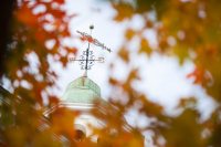 Fall foliage frames the Hathorn Hall weathervane. (Sarah Crosby/Bates College)
