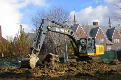 A power shovel nags a tree stump on the 45 Campus Ave. lot on Nov. 18, 2014. (Doug Hubley/Bates College)