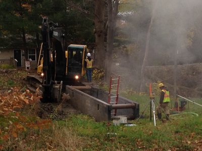 With a power shovel and a trench box, workers make a storm drain connection on Bardwell Street on Nov. 6, 2014. (Doug Hubley/Bates College)