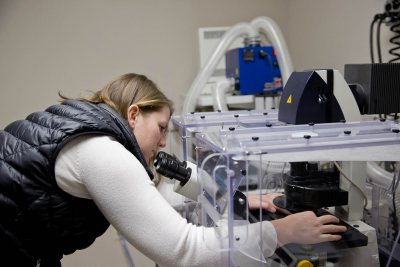 Biology professor Larissa Williams manipulates the specimen stage of Bates' Leica SP8 confocal microscope. (Phyllis Graber Jensen/Bates College)