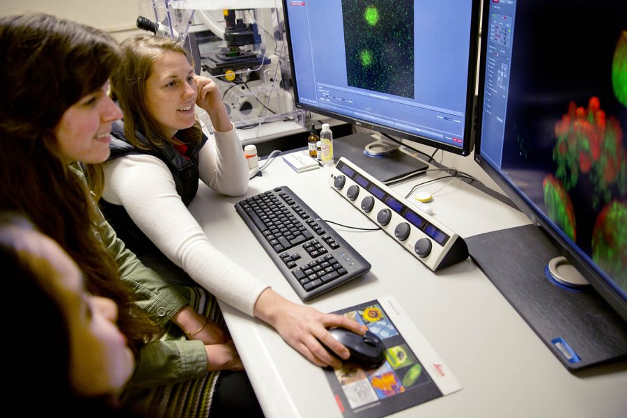 From left, seniors Minh-Tam Pham and Kathleen Morrill look on as their adviser, biology professor Larissa Williams, scans protein molecules with Bates' new confocal microscope. (Phyllis Graber Jensen/Bates College)