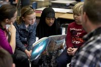 Bates men's lacrosse coach Peter Lasagna (with back to camera) works with fourth-graders at Martel School on Jan. 21, 2015, during the annual Rev. Dr. Martin Luther King Jr. Read-In. (Phyllis Graber Jensen/Bates College)