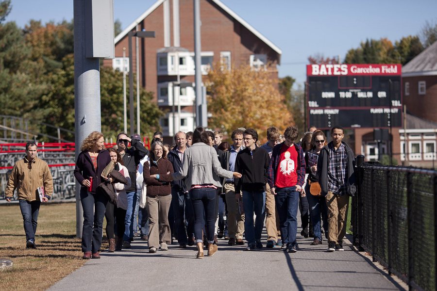 An Admission tour guide leads a group of future students and parents on a tour of campus, passing by Garcelon Field on their way to Commons. (Phyllis Graber Jensen/Bates College)